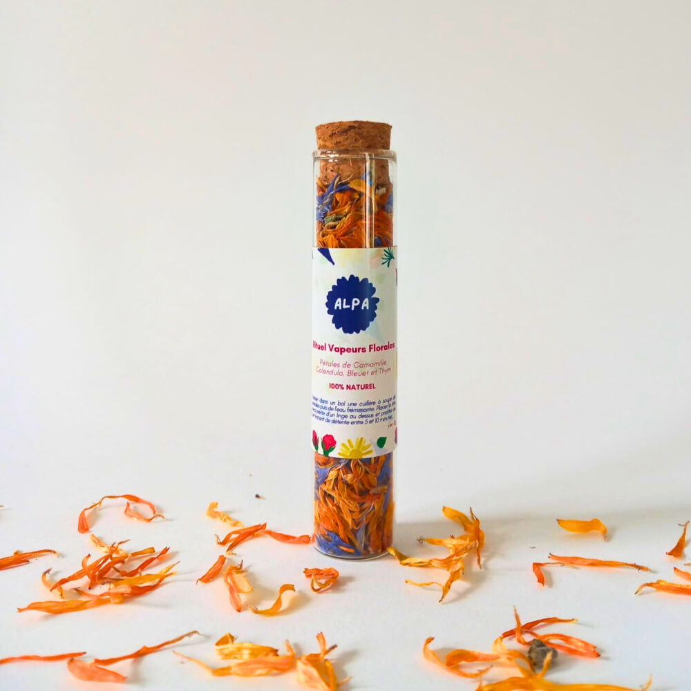Fiole en verre contenant un mélange de plantes naturelles, notamment des fleurs de camomille, calendula, bleuet et thym, destiné à l'inhalation florale.